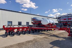 The Case IH Early Riser planter on display in front of a machine shed.