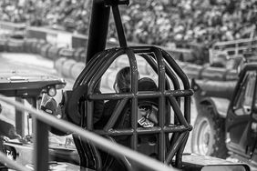 A black and white photo of a lady sitting in a pulling tractor