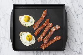 Eggs and bacon on frying pan. 