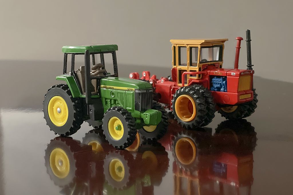 Die-cast John Deere 7810 and Versatile 125 tractors.