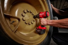 A Milwaukee The Milwaukee M18 Fuel half-inch high torque impact wrench used on a construction tire. 