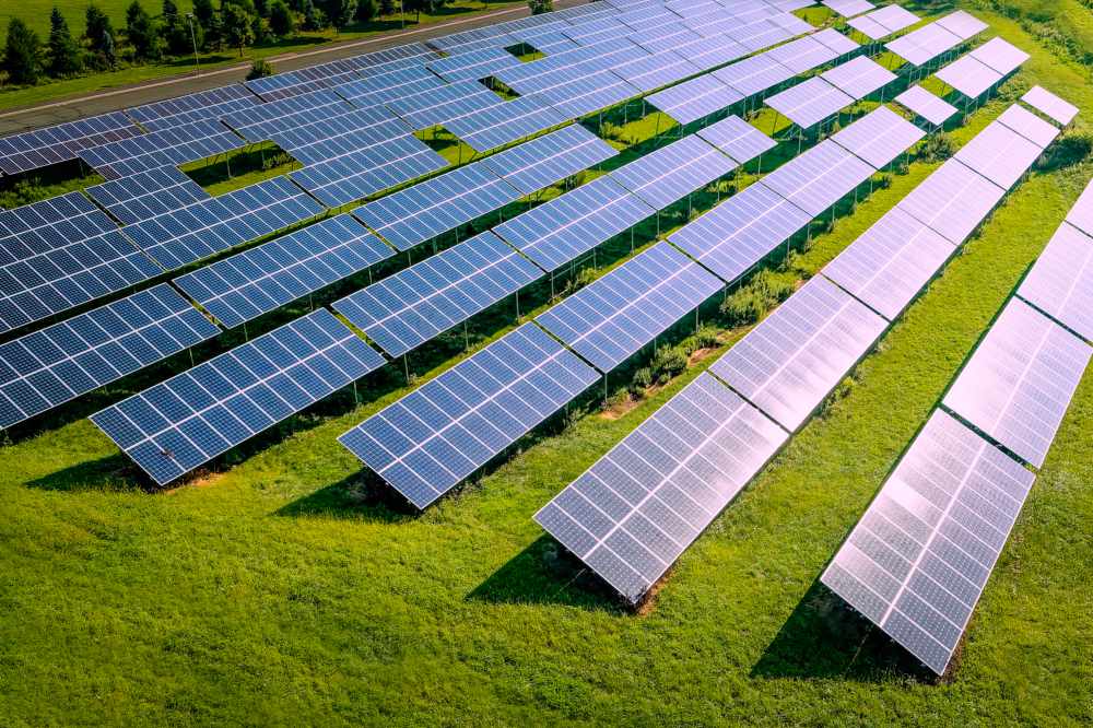 Sun glare reflects of the rows of rural solar panels.