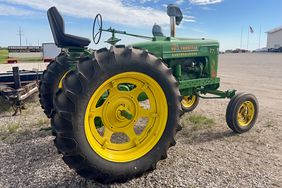 A Farmall M tractor painted in Deere green, with decals on the side reading "Full Throttle: Earthshakers."