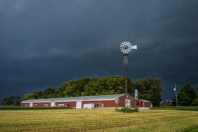 A storm rolls in over a farm.