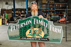 Erik Peterson holding Peterson Family Farm sign