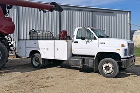 white service truck parked on gravel