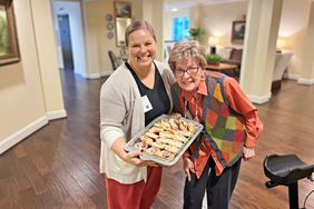 Kendall and Dorcille Vanderslice with a pan of cinnamon rolls