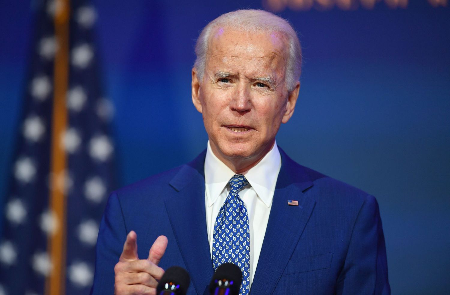 Joe Biden points from behind a podium