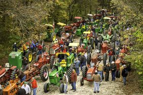 A plethora of antique tractors during a ride.