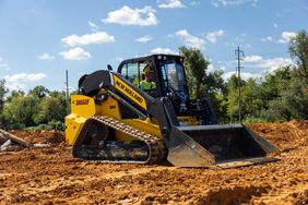 A yellow New Holland C362 track loader on construction site.