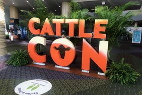 Orange sign that reads "Cattle Con" at entrance of convention