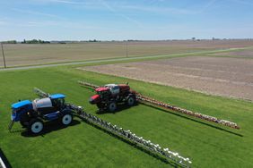 A New Holland sprayer and Case IH sprayer in the field.