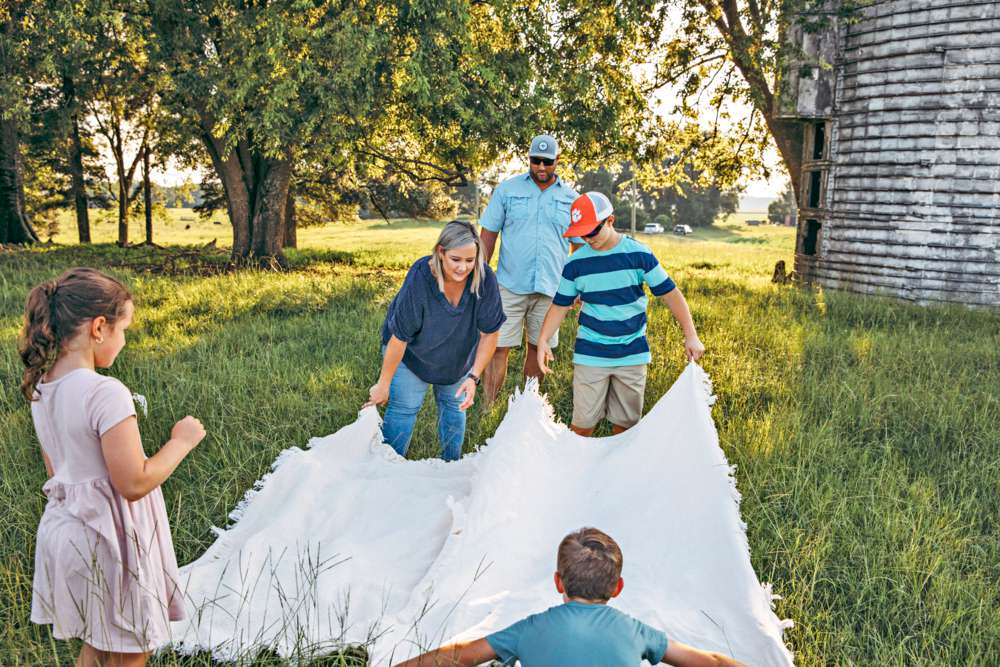 Woodard family spreading out one of their blankets on their family farm