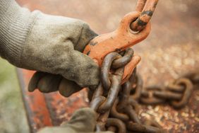 A farmer adjusting chains.