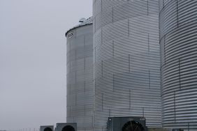 Three grain silos with aeration fans.