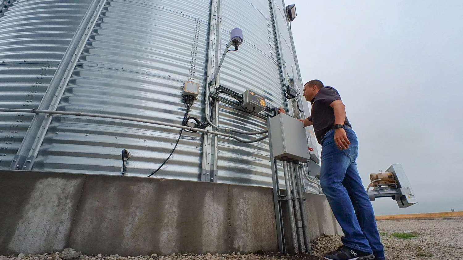 A farmer checks on the GSI GrainVue tool attached to the side of a grain bin.cf