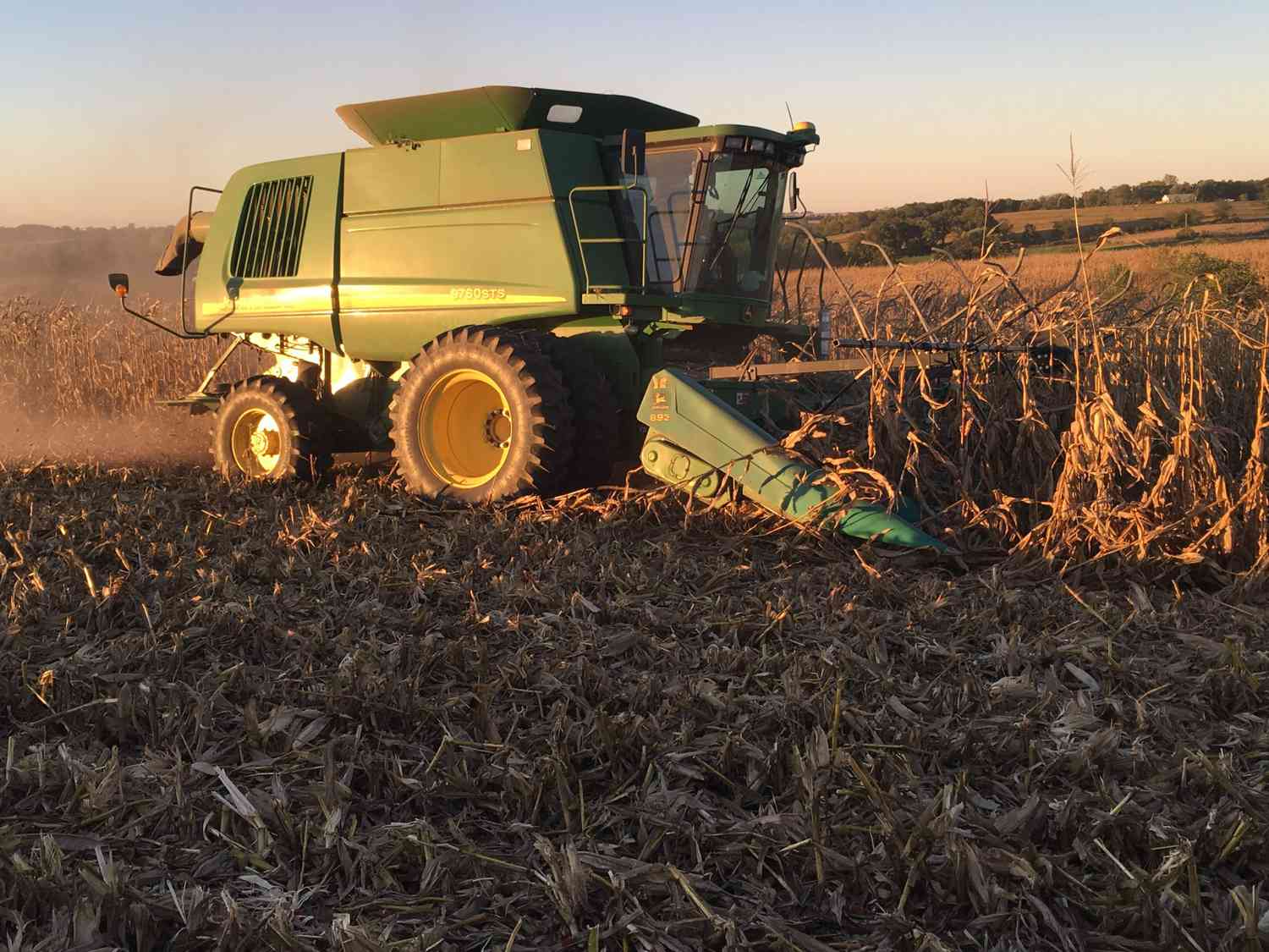 A John Deere combine harvesting corn.