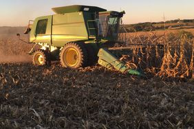 A John Deere combine harvesting corn.