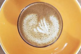 A cup of coffee on a yellow serving dish