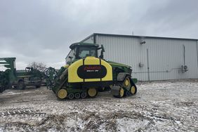 A John Deere 8RX equipped with Demco tanks sits in a farmyard in Iowa with a little bit of snow