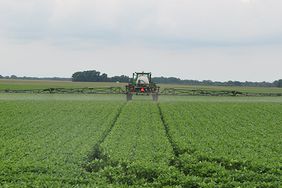 A John Deere sprayer in a soybean field.