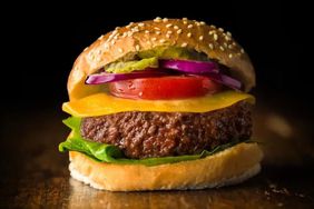 A closeup of a cheeseburger with all the fixings, including lab-grown hamburger.