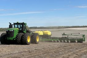 A dual John Deere tractor pulls a John Deere planter in a South Dakota field