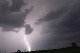 Lighting strikes over a field.