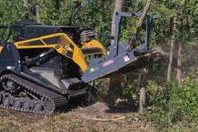 The Bad Ax disc mulcher attached to a skid steer and chopping through trees.