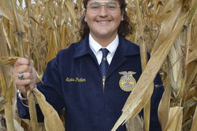 Luke Prater in a cornfield wearing an FFA jacket