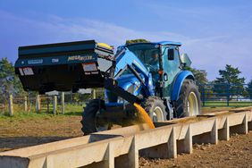 Danuser Mega Mixer handling bucket on a New Holland tractor dispensing livestock feed