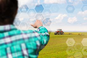 An illustration of smart farming with a tractor in the background.