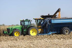 A New Holland combine unloads into a Kinze grain cart.