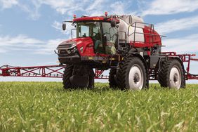 Red Case IH Patriot 4450 sprayer in a green field with booms unfolded