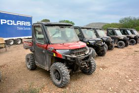 A lineup of the 2025 Polaris Ranger XP 1000 NorthStar edition UTVs, covered in dust after a long day of driving.