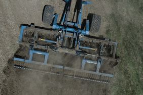 Drone photo of a blue Kinze Mach Till running in a field