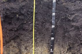 Hole in ground with measuring strips top to bottom