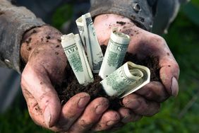 A farmer holding money in his hands.