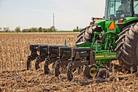 The Great Plains VT1500 Sub-Soiler pulled by a John Deere tractor.