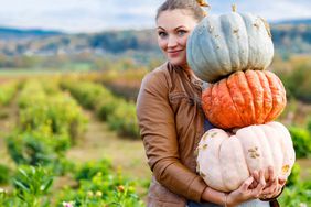 A woman holding pumpkins.