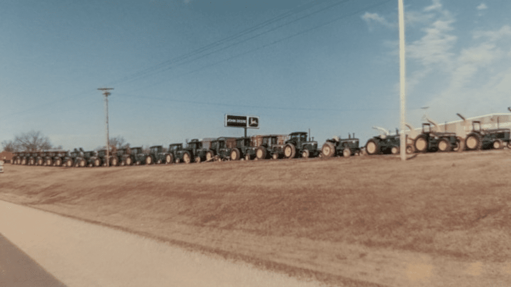 A line of John Deere tractors in front of the dealership