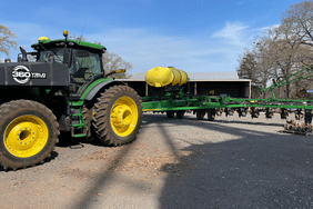 John Deere tractor and green strip finisher sitting outside machine shed on Alabama farm