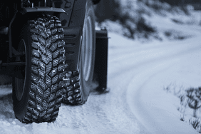 Nokian Tyres on a tractor on a snowy road.